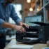 A technician is refilling a laser-printer cartridge with toner at an office workstation.