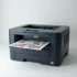 Kỹ thuật viên rót toner vào hộp mực máy in trắng đen trong môi trường văn phòng, với các công cụ hỗ trợ được nhìn thấy trong cảnh.